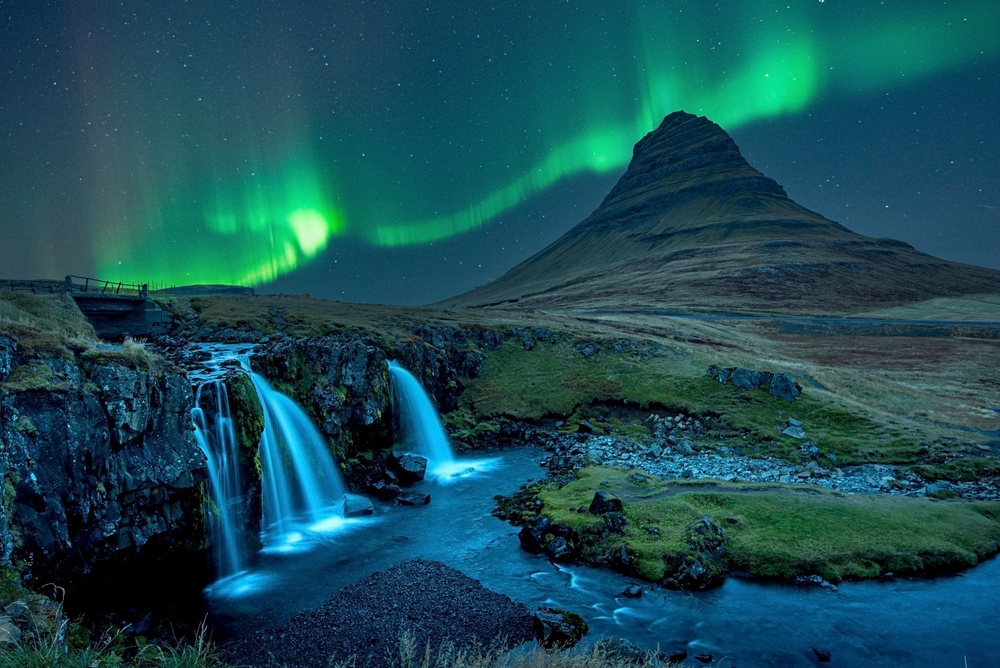 The northern lights glowing green over an Icelandic landscape